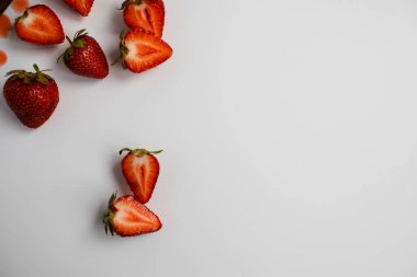 Kesik çilek parçalarının manzarası. Beyaz arkaplanda metin için boş alan.