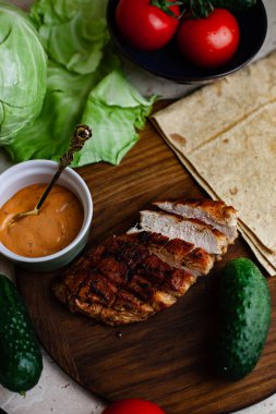 Ev yapımı shawarma pişirmeden önce kızarmış tavuk eti tabakta yatıyor.