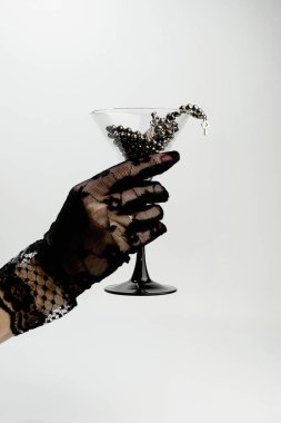 Şatafatlı, el yapımı, dantel eldivenli kristal bir bardakta bilezikler.