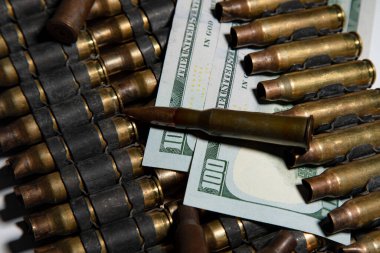 Amerikan dolarlarının üzerinde duran kurşunlardan oluşan karanlık ve duygusal bir hayat kanlı para fikrini ve savaşın kar güdümlü doğasını çağrıştırıyor.