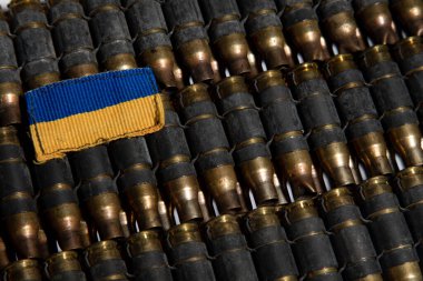 Çok sayıda mermi kovanının arka planında küçük bir Ukrayna bayrağı