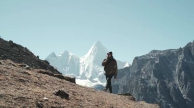 Asyalı erkek dağcı yading ulusal parkında daocheng, sichuan, china, arka planda jampayang zirvesi