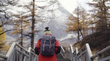 Asya 'lı kadın turist, Çin' in Sichuan bölgesindeki ulusal parktaki kar dağının zirvesine çıkan basamakları tırmanıyor.