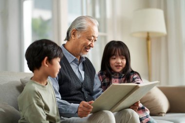 senior asian grandfather having a good time with two grandchildren at home clipart