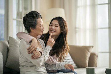 happy senior asian mother and adult daughter having a good time at home clipart