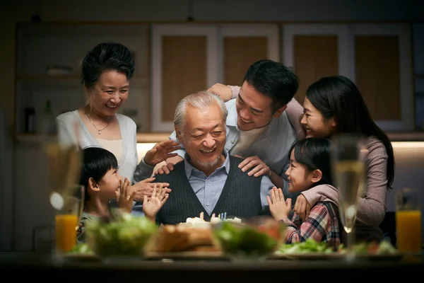 happy three generation asian family celebrating grandpa\'s birthday at home
