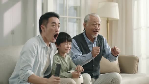 Asian Son Father Grandfather Watching Live Broadcasting Football Match Together — Stock video