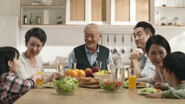 Trzy Pokolenia Azjatyckiej Rodziny Siedzi Przy Stole Mając Przyjemną Rozmowę — Wideo stockowe