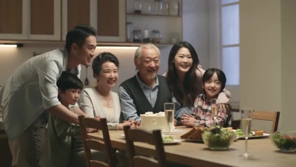 おばあちゃんとおじいちゃんの結婚記念日を祝いながら3世代のアジア系家族が集合写真を撮る — ストック動画