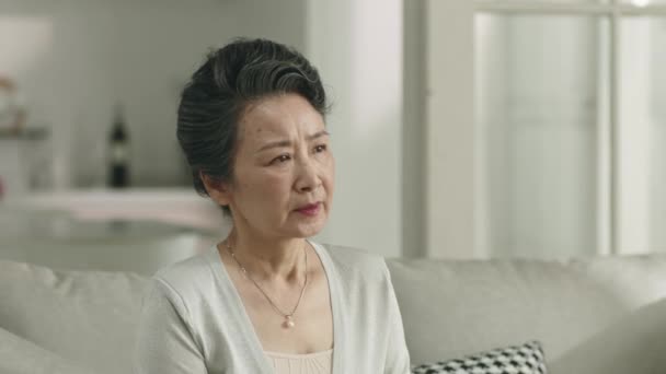 Unhappy Senior Asian Woman Sitting Alone Couch Home Sighing — Video Stock