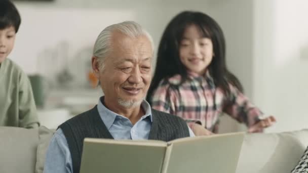 Loving Asian Grandpa Two Grandchildren Relaxing Home — Stockvideo