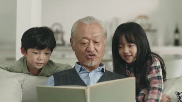 Asian Grandpa Reading Book Together Two Grandchildren — Stock Video