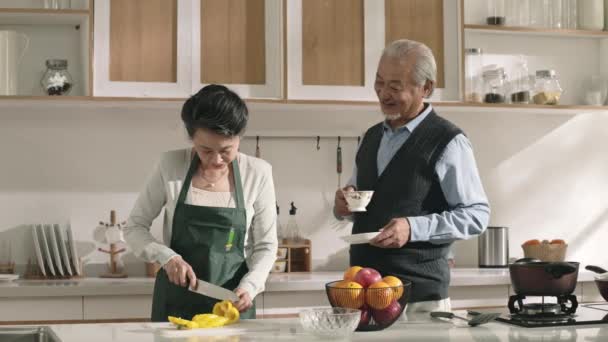 Mutlu Asyalı Koca Kahve Içiyor Evde Yemek Hazırlayan Eşiyle Sohbet — Stok video