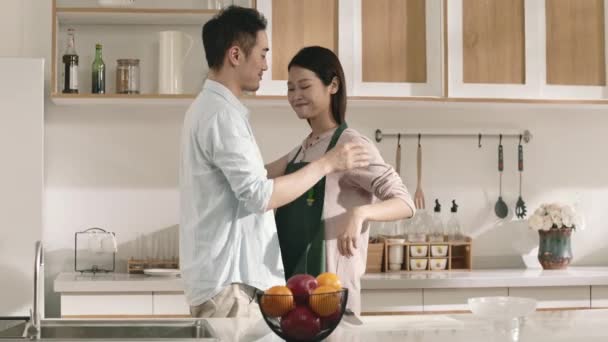 Young Loving Asian Husband Tying Apron Wife Kitchen Home — Stock Video