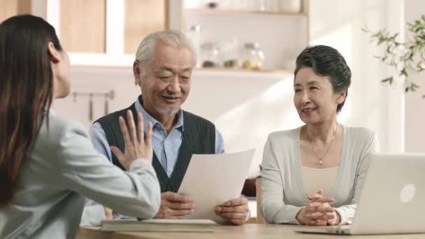 アジア系の高齢者の夫婦は自宅で書類にサインして — ストック動画