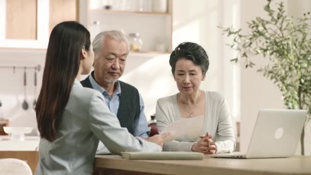Cautious Senior Asian Couple Looking Confused Sales Woman Introducing Financial — Stock Video