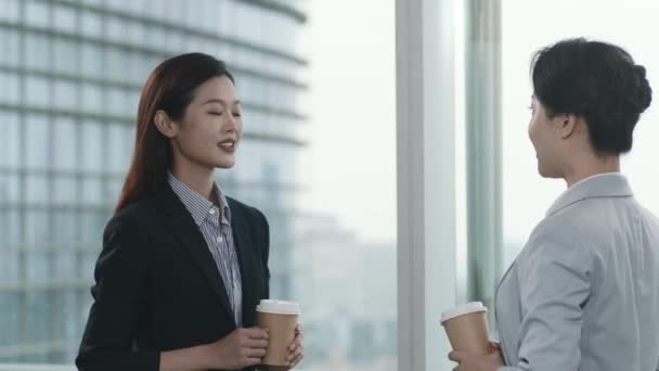 Asyalı Kadını Modern Ofiste Pencerenin Önünde Dikilip Sohbet Ediyorlar — Stok video