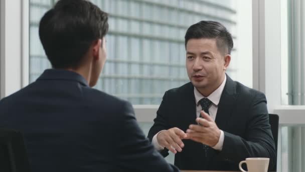 Dwóch Azjatyckich Biznesmenów Rozmawiających Twarzą Twarz Nowoczesnym Biurze — Wideo stockowe