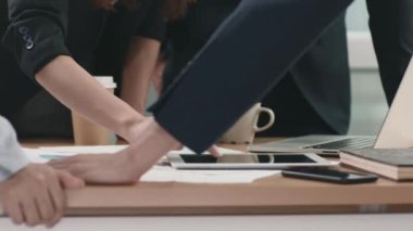 Asyalı iş adamlarından oluşan bir ekip ofiste birlikte çalışıyor verileri analiz ediyor ve iş stratejilerini tartışıyorlar.