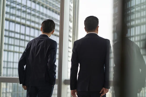 Zwei Asiatische Geschäftsleute Stehen Fenster Und Unterhalten Sich Beim Blick — Stockfoto