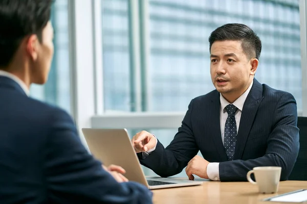 2人のアジア系のビジネスマンが現代のオフィスで顔を合わせ — ストック写真