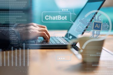 Masada oturmuş bir ChatBot 'la dizüstü bilgisayar kullanarak sohbet eden biri.