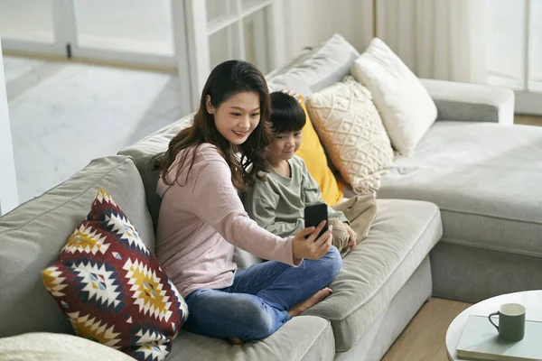 Šťastný Asijské Matka Syn Sedí Rodinném Gauči Doma Přičemž Selfie — Stock fotografie
