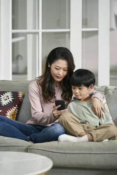 Счастливая Азиатская Мать Сын Сидят Семейном Диване Глядя Фотографии Мобильных — стоковое фото
