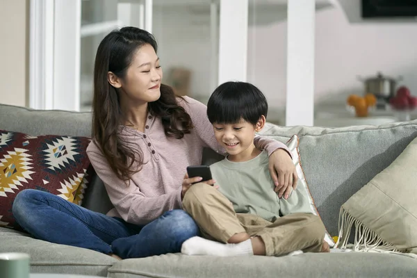 Feliz Asiático Mãe Filho Sentado Família Sofá Olhando Para Celular — Fotografia de Stock