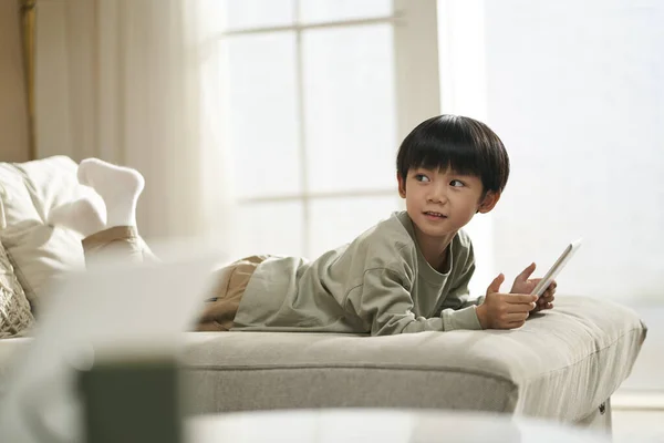 Carino Asiatico Bambino Sdraiato Anteriore Famiglia Divano Casa Possesso Digitale — Foto Stock