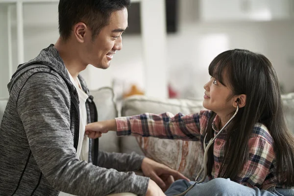 年轻的亚洲父亲和7岁的女儿在家里玩医生和病人游戏 — 图库照片