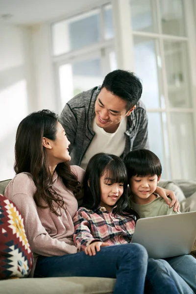아시아인 부부와 가집에 쇼파에 노트북 컴퓨터를 사용하여 영화를 — 스톡 사진