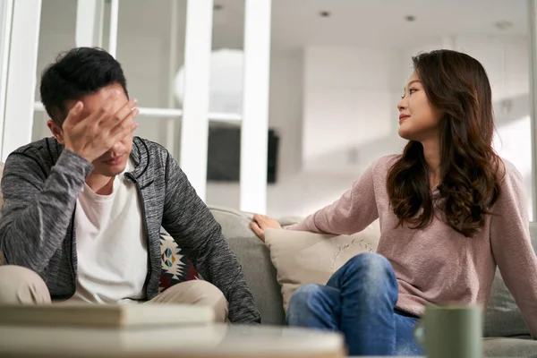 一对年轻的亚洲夫妇坐在家里的沙发上谈论他们的婚姻问题 — 图库照片