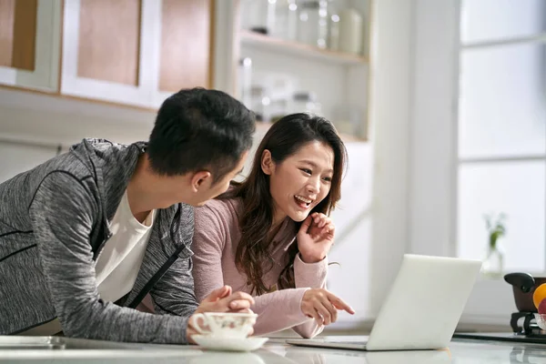 一对年轻的亚洲夫妇在家里的厨房里一起使用笔记本电脑 — 图库照片