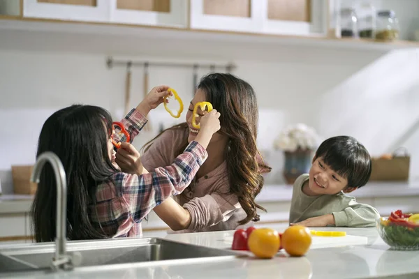 年轻的亚洲母亲和两个孩子在家里的厨房里玩得很开心 — 图库照片