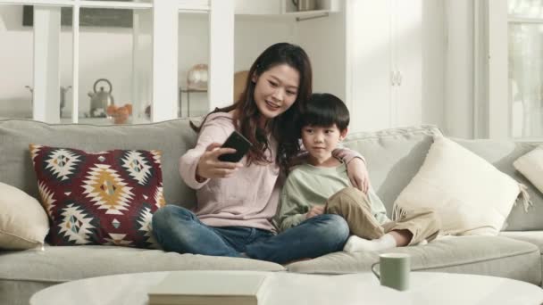 Młody Azji Matka Pięć Lat Syn Siedzi Kanapie Domu Biorąc — Wideo stockowe