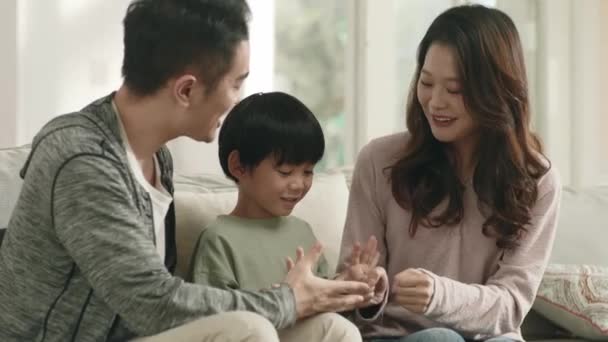 快乐的亚洲家庭坐在沙发上 在家里共度时光 — 图库视频影像