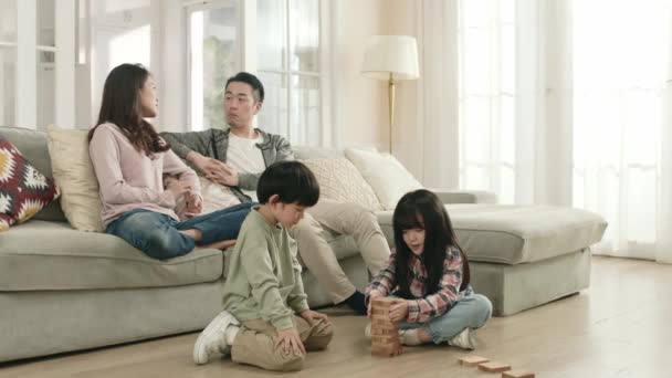 Twee Jonge Aziatische Kinderen Zitten Vloer Spelen Met Bouwstenen Terwijl — Stockvideo