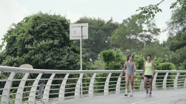 Due Giovani Asiatiche Amiche Che Camminano Rilassanti Parlando Mentre Esercitano — Video Stock