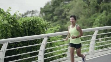 young asian woman jogging running outdoors in seaside park, happy and smiling