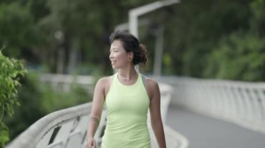 young asian woman female jogger athlete walking relaxing while exercising outdoors 