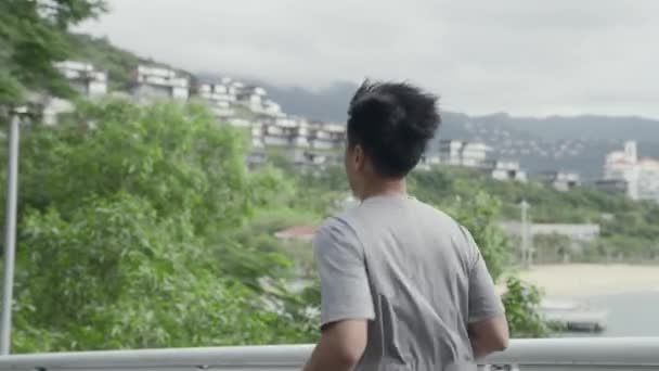 vue latérale de jeune asiatique homme jogging courir à l'extérieur dans le parc