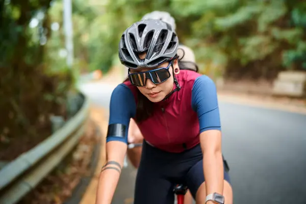 若いアジアの女性サイクリスト 自転車に乗る 田舎の道路で屋外 ロイヤリティフリーのストック写真