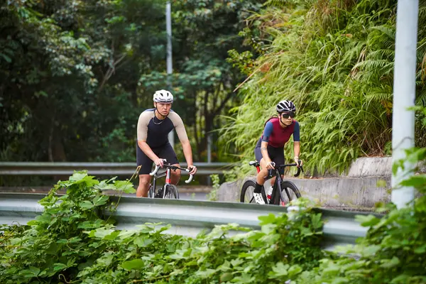 年轻的亚洲夫妇骑自行车在乡间路上 — 图库照片