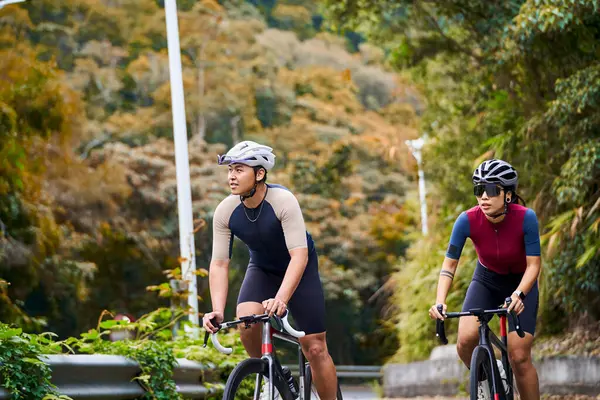 年轻的亚洲夫妇骑自行车在乡间路上 — 图库照片