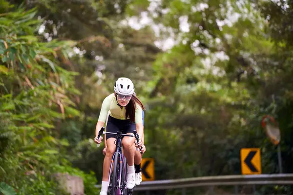 若いアジアのプロサイクリストのグループ 田舎の道路で自転車のトレーニングに乗って ストック写真