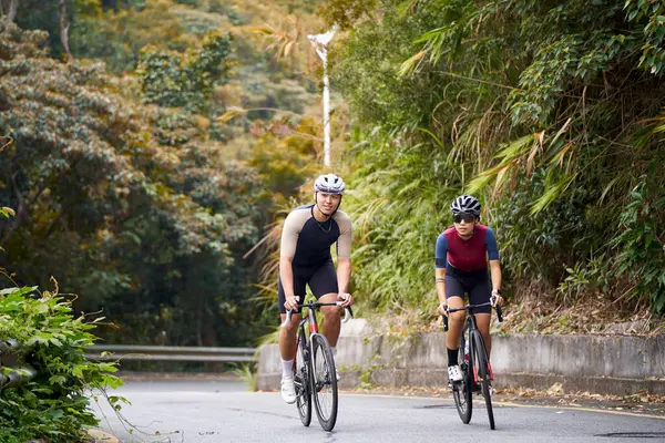 若いアジアのカップルの自転車に乗るサイクリスト 田舎の道路 ストック写真