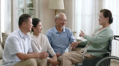 Bir grup üst düzey Asyalı erkek ve kadın evde toplanıp keyifli bir sohbet ediyorlar.