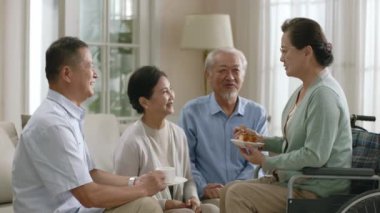 İki kıdemli Asyalı çift evdeki kanepede oturup keyifli bir sohbet yapıyorlar.