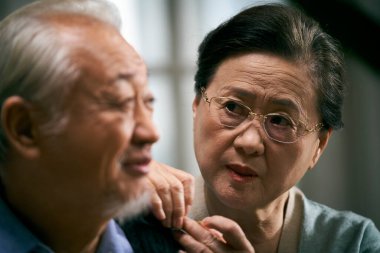 İlgili üst düzey Asyalı kadın endişeyle kocaya bakıyor.